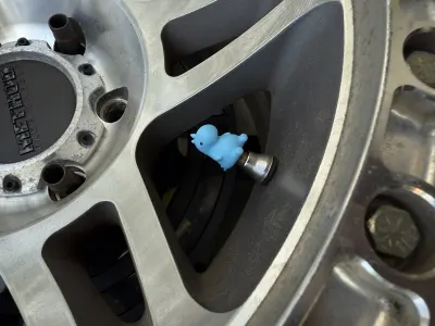 Image 3 : Bouchons de valve en forme de petit dino sur une jante (photo 3)