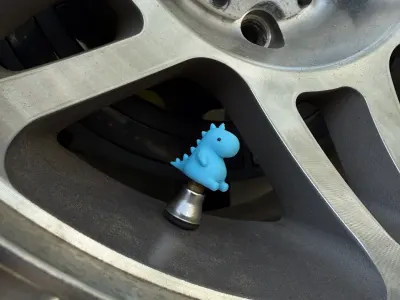 Bouchons de valve en forme de petit dino sur une jante (photo 1)